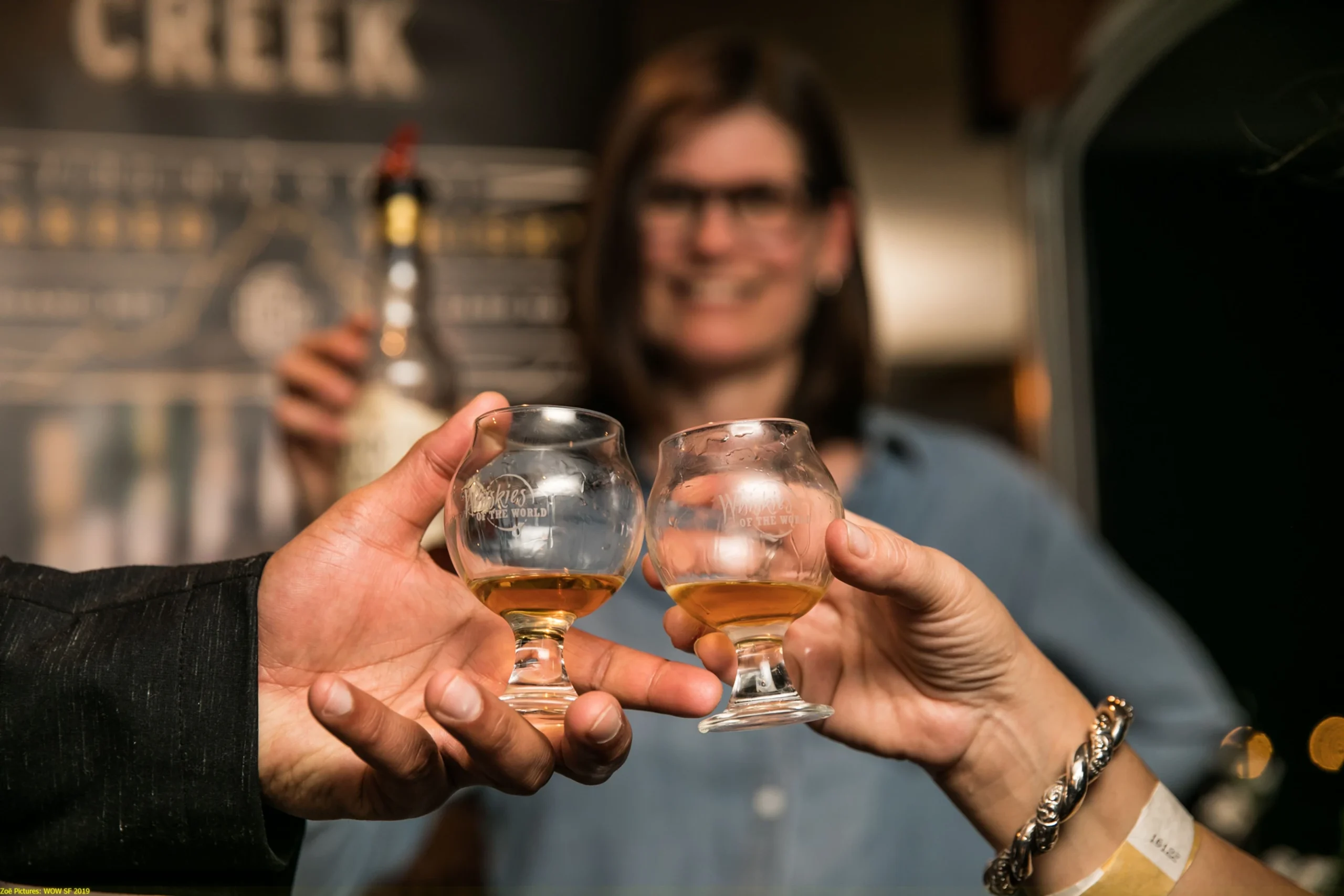 Two guests toasting with Glencairn glasses at a Whiskey EDU tasting